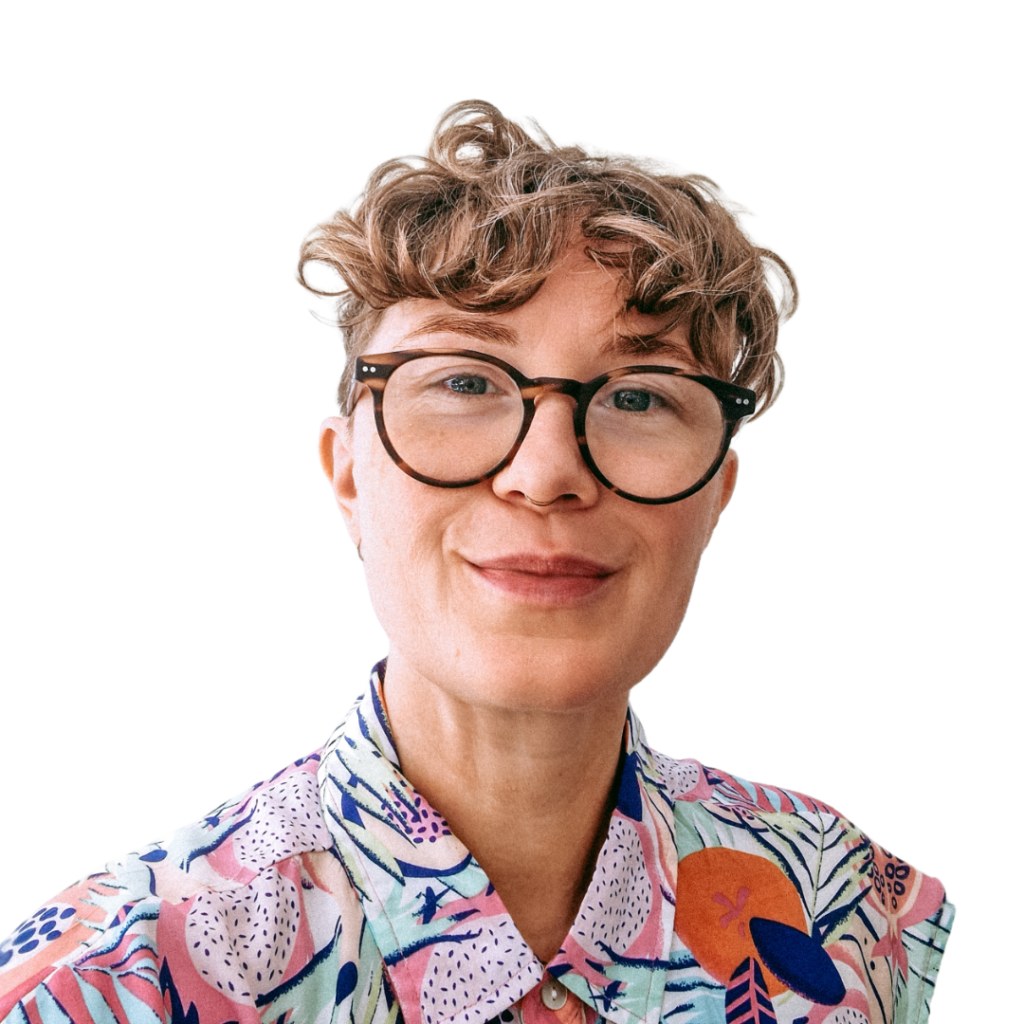 Portrait of Jen Bell, wearing glasses and a colourful shirt.