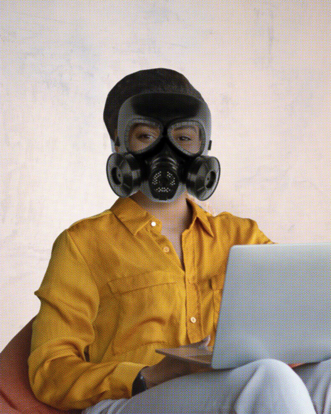 A Black woman therapist wearing a mustard yellow silk shirt and a gas mask sits facing the viewer, holding a laptop.  Her eyes, visible through the mask, look warm and friendly. 