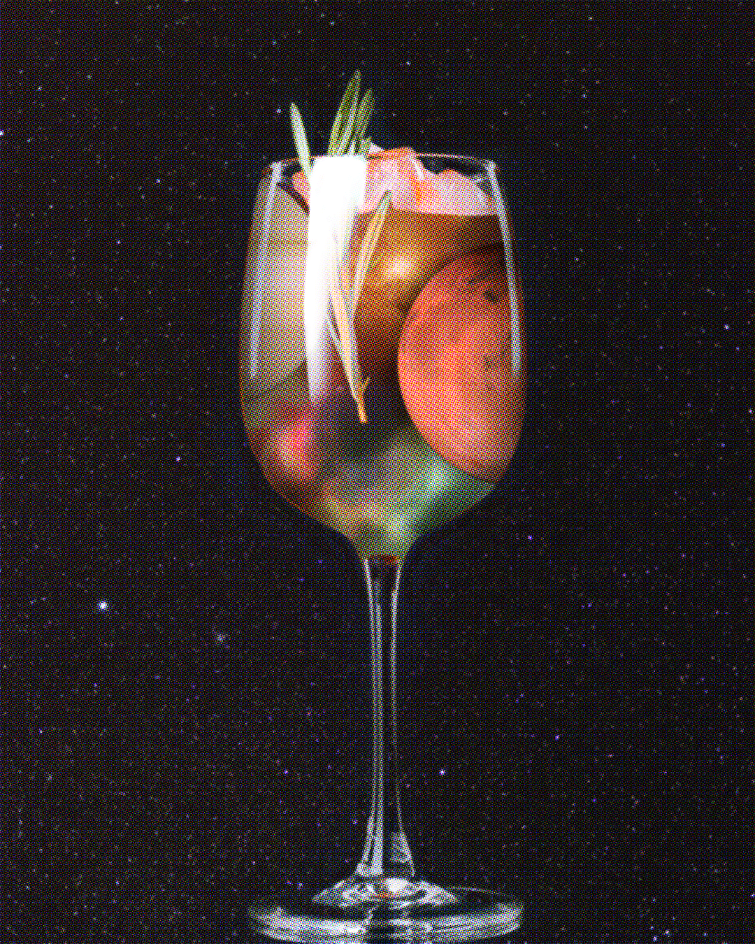 A cocktail glass against a background of a starry sky. Inside the cocktail are slices of two planets, a multicoloured galaxy, some ice cubes and a sprig of rosemary.